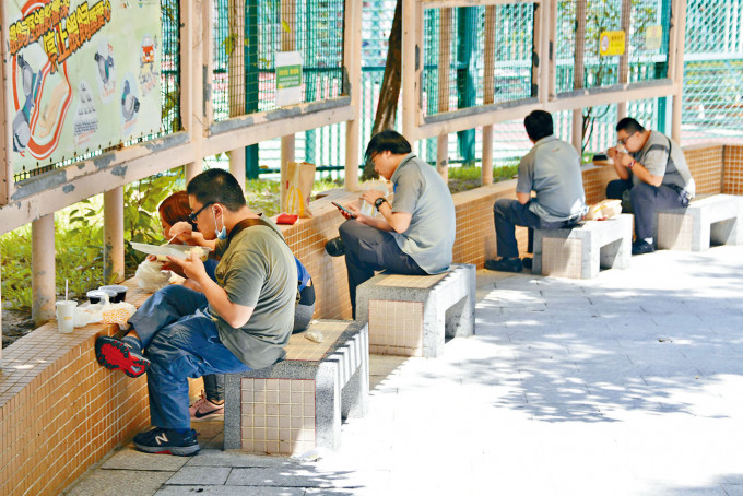 烈日當空，市民在公園「面壁」開飯。