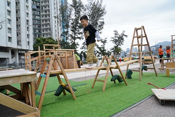 簡單利用木板和木梯建成的「獨木橋」,已令小孩樂而忘返。